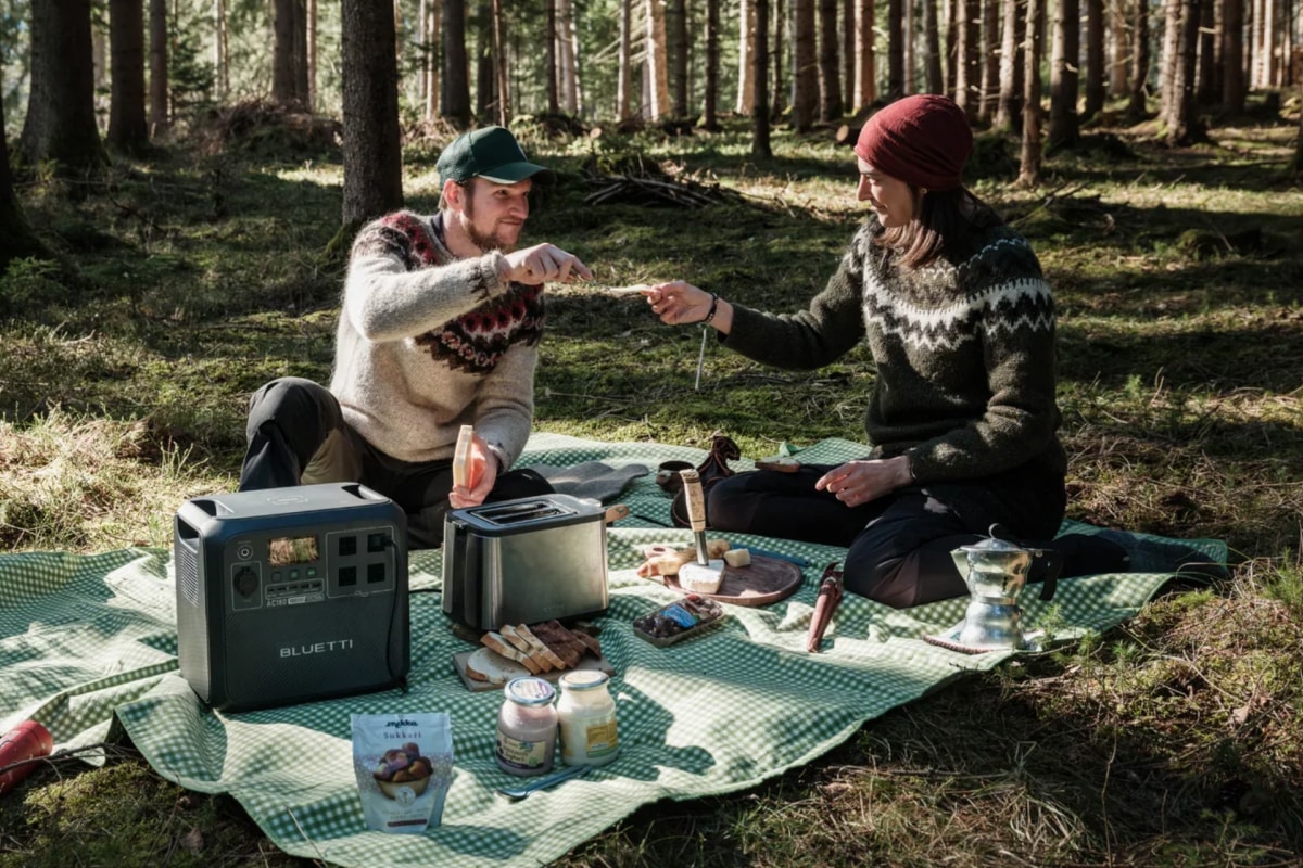 Bluetti AC180 size comparison with laptop and water bottle